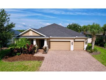Charming one-story home featuring a brick driveway, two-car garage, and lush landscaping at 3643 Arbor Chase Dr, Palm Harbor, FL 34683