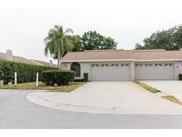 Charming single-story home with a two-car garage, manicured landscaping, and a welcoming entrance at 4032 Salem Square Ct, Palm Harbor, FL 34685