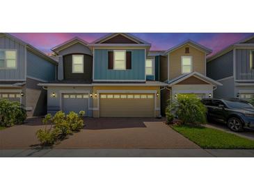 Charming multi-colored townhome featuring a brick driveway, attached garages, and well-maintained landscaping at 4316 Sailplane Ct, Wesley Chapel, FL 33545
