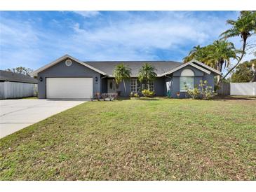 Charming single-story home with well-maintained lawn, attached garage, and inviting front entrance with decorative palms at 728 Camrose Dr. Dr, Brandon, FL 33510