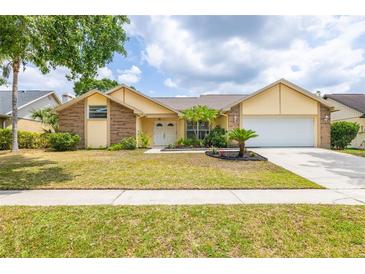 Charming home featuring mature landscaping, a well-manicured lawn, and an attached two-car garage at 1426 Buckner Rd, Valrico, FL 33596