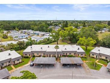 Low angle shot of a multi-unit residential building with attached covered parking and well-maintained landscaping at 4305 Summersun Dr, New Port Richey, FL 34652