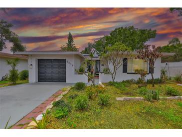 Charming single-story home featuring a well-maintained lawn and mature trees at sunset at 5219 4Th S St, St Petersburg, FL 33705