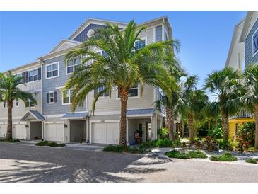 Charming townhome with tropical landscaping, colorful exterior, and a convenient one-car garage, perfect for coastal living at 6140 Marina Cove S Way, St Petersburg, FL 33712