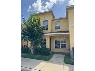 Two-story townhome with neutral exterior, well-maintained landscaping, and sunny curb appeal at 6250 Maisie Rd, Zephyrhills, FL 33542