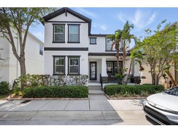 Charming two-story home with manicured landscaping and a welcoming front porch, and attractive black and white design at 7307 S Trask St, Tampa, FL 33616