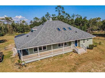 Charming single-story home with a spacious wraparound porch and a well-maintained yard at 8755 Ogleby Creek Rd, Myakka City, FL 34251