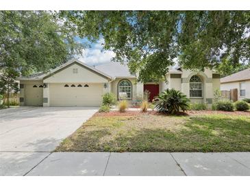Charming single-story home with manicured lawn and mature trees creating a welcoming curb appeal at 9422 Clover Glen Dr, Riverview, FL 33569