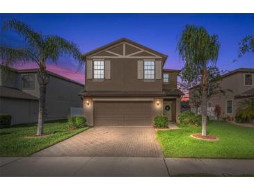 Charming two-story home featuring a paved driveway, two-car garage and manicured lawn at 1726 Hadden Hall Pl, Trinity, FL 34655