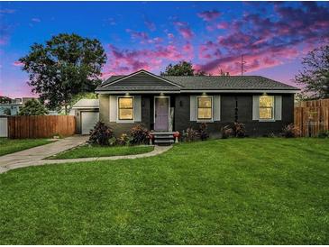Charming home showcasing a well-manicured lawn, fresh landscaping, and inviting curb appeal at sunset at 2122 W Ferris Ave, Tampa, FL 33603