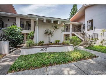Well-maintained condo complex exterior with manicured landscaping and inviting walkways at 300 S Florida Ave # 200J, Tarpon Springs, FL 34689