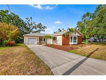 Charming single-story home with a well-manicured lawn and a long driveway to an attached garage at 3417 1St W Ave, Bradenton, FL 34205