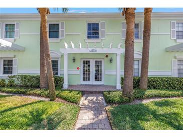 Inviting building entrance with palm trees, a white pergola, and brick walkway at 5037 Starfish Se Dr # A, St Petersburg, FL 33705
