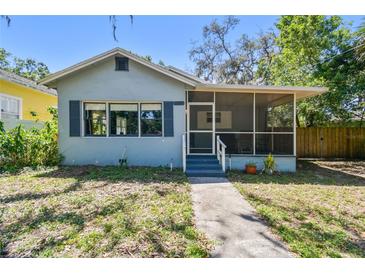 Charming home with a screened-in front porch, landscaped yard, and classic architectural details at 5806 N 9Th St, Tampa, FL 33604