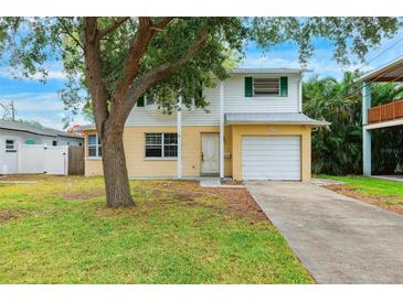 Charming two-story home features a well-maintained lawn, inviting curb appeal, and an attached garage at 1810 Maryland Ne Ave, St Petersburg, FL 33703