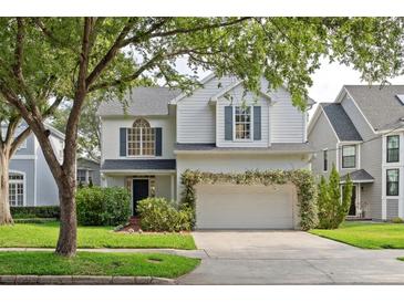 Charming two-story home with a white brick facade, landscaped yard, and attached garage at 3619 W Leona St, Tampa, FL 33629