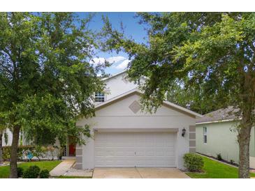 Charming two-story home featuring a two-car garage, well-maintained lawn and mature trees in a Gathering-friendly neighborhood at 396 Winthrop Dr, Spring Hill, FL 34609
