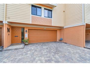 A home exterior with a brick driveway, door on the left, and a two-car garage at 531 Sandy Hook Rd, Treasure Island, FL 33706
