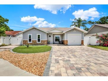 Charming single-story home with manicured lawn, stone accents, and a patterned brick driveway at 5875 Darren N Ct, Clearwater, FL 33760
