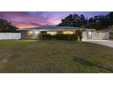 Charming single-story home featuring a well-manicured lawn and a neatly landscaped front yard at 895 Joan St, Dunedin, FL 34698