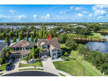 Stunning aerial view of a home with lush landscaping and a private lake in a desirable community at 11320 Lazy Hickory Ln, Tampa, FL 33635