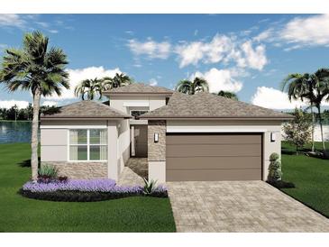 Beautifully landscaped home featuring a large driveway and neutral stucco exterior with brick accents at 3198 Malta Ave, Wesley Chapel, FL 33543