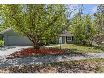 Charming single Gathering home featuring mature landscaping and a welcoming front yard and attached garage at 3668 Pond View Ln, Sarasota, FL 34235