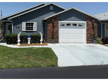 Charming single-story home with brick accents, a well-maintained lawn, and a two-car garage at 37401 Teaberry Loop, Zephyrhills, FL 33542