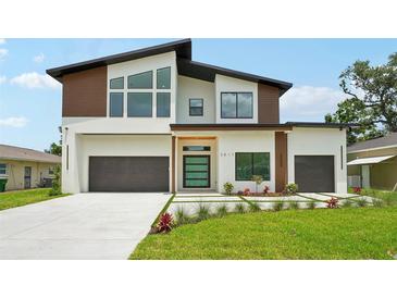 Modern two-story home boasts a contemporary design with a well-manicured lawn and a spacious two-car garage at 3817 W San Nicholas St, Tampa, FL 33629
