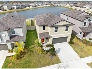 Beautiful two-story home with a well-manicured lawn, two-car garage, and peaceful water view at 9313 Lemon Drop Loop, Sun City Center, FL 33573