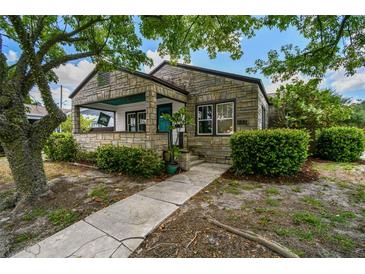 Charming stone home with a welcoming covered front porch and well-maintained landscaping at 233 24Th N St, St Petersburg, FL 33713