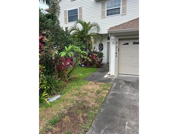 Two-story home exterior with a well manicured front yard and attached garage at 3145 Meta Ct, Largo, FL 33771