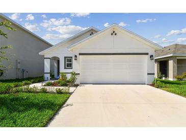 Charming single-Gathering home featuring a two-car garage, manicured lawn, and neutral color scheme at 36673 Spanish Rose Dr, Dade City, FL 33525