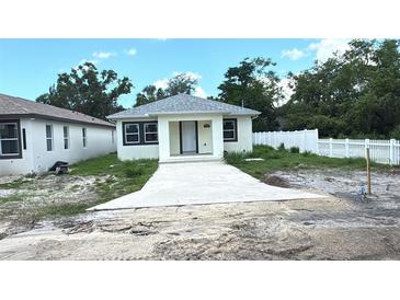 Charming single-story home featuring a fresh exterior, new driveway and a white picket fence at 3704 Smith Tree St, Tampa, FL 33619