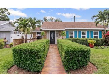 Charming home with a manicured lawn, walkway, black door, and vibrant blue shutters providing a welcoming entrance at 3800 6Th N Ave, St Petersburg, FL 33713