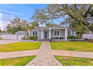Charming home featuring a manicured lawn, covered entry, and stone walkway at 493 Lucerne Ave, Tampa, FL 33606