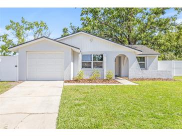 Charming single-story home with a well-manicured lawn, neutral tones, and an attached single-car garage at 6404 Monterey Blvd, Tampa, FL 33625