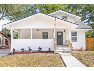 Charming renovated two-story home featuring a covered porch, black door, fresh landscaping and newly poured concrete steps at 7 Hamilton Heath Dr, Tampa, FL 33604