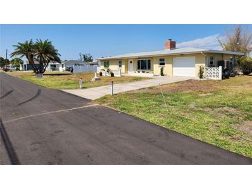 Charming single-story home with a well-maintained yard, driveway, and a glimpse of the neighborhood street at 1447 Lemon Bay Dr, Englewood, FL 34223