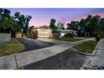 Charming home featuring a well-maintained lawn, large windows, and a driveway at sunset at 2018 21St S St, St Petersburg, FL 33712