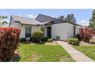 Well-maintained single-story home with a neatly manicured lawn and walkway at 322 Windrush Loop # 22, Tarpon Springs, FL 34689