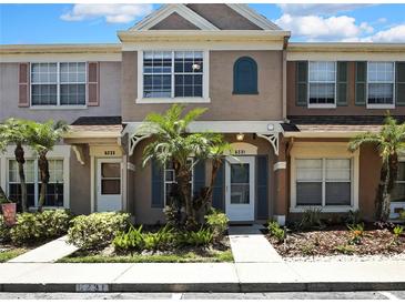 Charming townhome featuring colorful shutters, tropical landscaping, and a welcoming entrance at 6231 Bayside Key Dr, Tampa, FL 33615