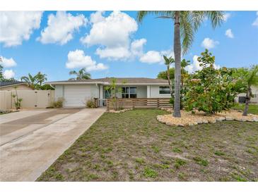 Charming single-story home with well-maintained landscaping and an inviting front yard at 7909 Canna Dr, Port Richey, FL 34668