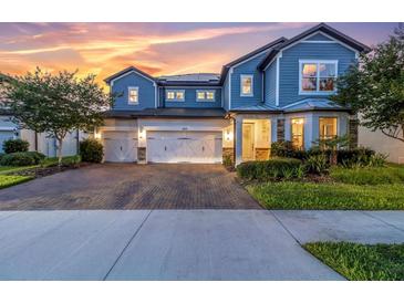 Beautiful two-story home with a three-car garage and attractive landscaping at sunset at 2641 Whittler Br, Odessa, FL 33556
