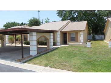 Charming single-story home with a covered carport and well-maintained front yard at 4736 Sunny Loop, Holiday, FL 34690