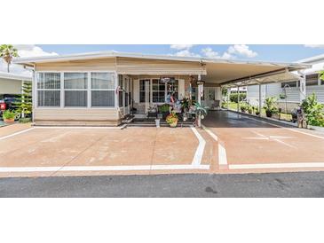 Charming single-story home with a covered carport and decorated porch, perfect for relaxing outdoors at 7053 El Conquistador St, Zephyrhills, FL 33541