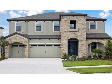 Beautiful two-story home featuring a three-car garage and stone accents at 13137 Wellspring Dr, Lithia, FL 33547