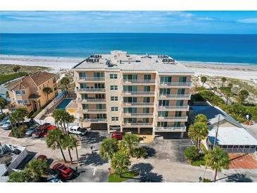 Beachfront condo building with balconies overlooking the ocean, parking and neighboring property at 13440 Gulf Blvd # 501, Madeira Beach, FL 33708