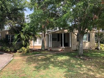 Charming single-story home featuring mature trees, a covered porch, and a well-maintained lawn at 1508 S Clark Ave, Tampa, FL 33629