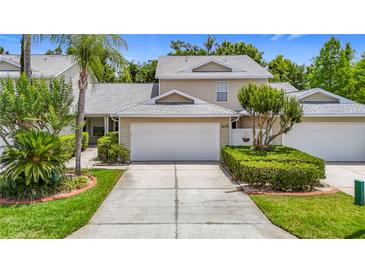 Charming two-story townhouse with a well-manicured lawn and attached two-car garage at 1628 Lullwater Ln, Lutz, FL 33549